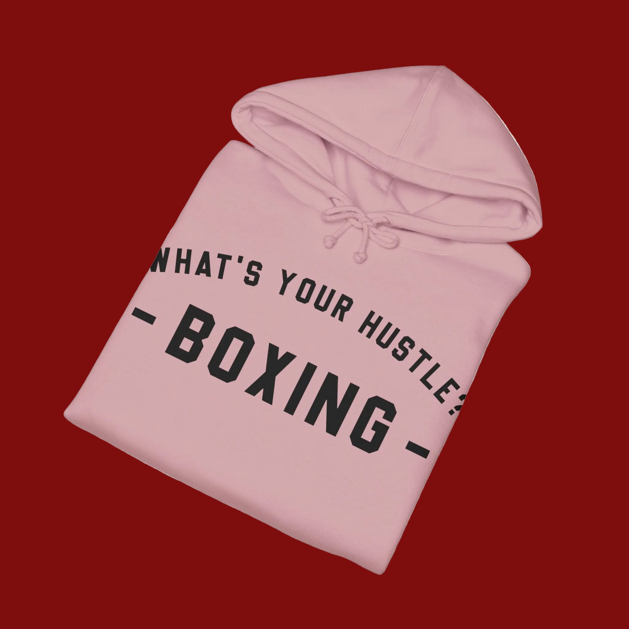 A light pink pullover hoodie with black text reading 'WHAT'S YOUR HUSTLE? BOXING' printed on the front, shown on a clean white background.