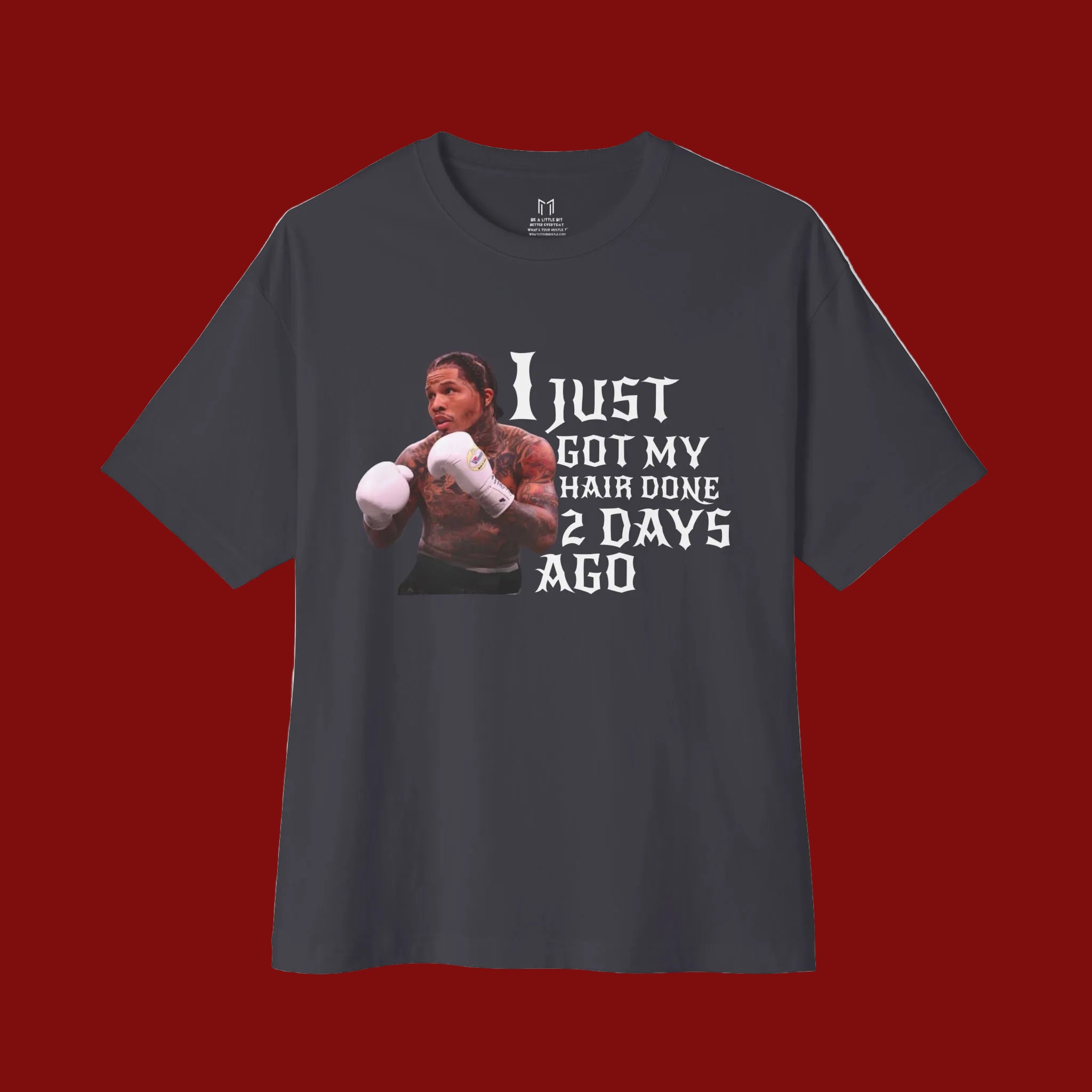 A dark charcoal gray short-sleeve t-shirt with a graphic print of a boxer and the text 'I JUST GOT MY HAIR DONE 2 DAYS AGO' in white, displayed on a clean white background.